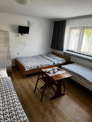 a room with two beds and a table in it at U Jaśka in Darłowo