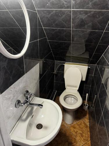 a bathroom with a white toilet and a sink at U Jaśka in Darłowo