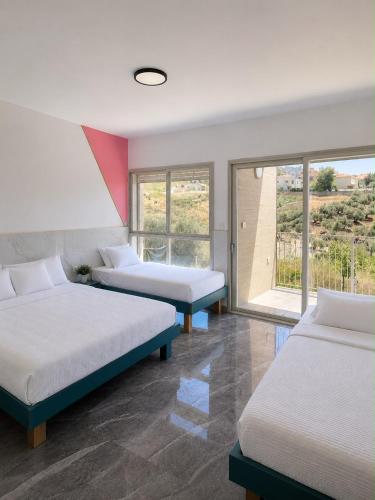 a room with two beds and a window at שושנת מטולה in Metulla