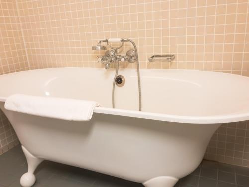 
a white bath tub sitting next to a white toilet at Hotel Villa Escale in De Panne

