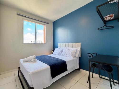 a blue bedroom with a bed and a desk at Apto com 2 quartos e A/C no Centro in Montes Claros