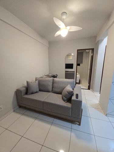 a living room with a couch and a ceiling fan at Apto com 2 quartos e A/C no Centro in Montes Claros