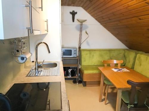 a kitchen with a green couch and a table at Ferienhaus Huber in Bleiburg