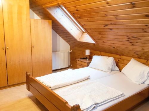 a large bed in a room with a wooden ceiling at Ferienhaus Huber in Bleiburg