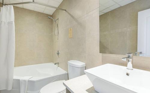 a bathroom with a white toilet and a sink at Hotel Montfort in Nicolet