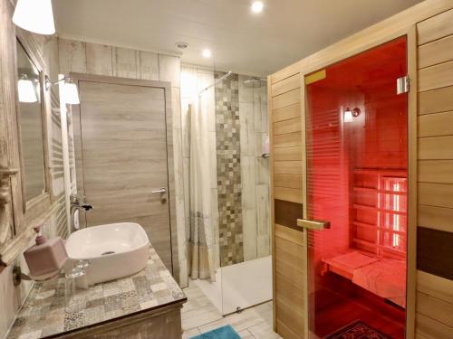 a bathroom with a white sink and a shower at Ferme de la Galoperie in Couvin