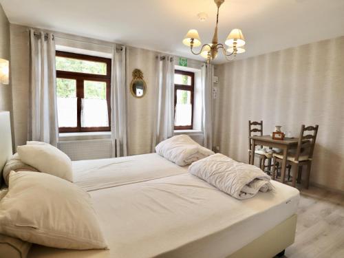a bedroom with two beds with white pillows and a table at Ferme de la Galoperie in Couvin