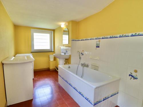 a bathroom with a tub and a sink at La Dépendance du Château in Huy