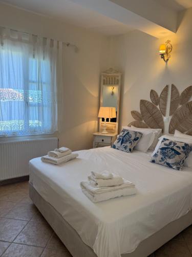 a bedroom with a large white bed with towels on it at Casa di Spetses in Spetses