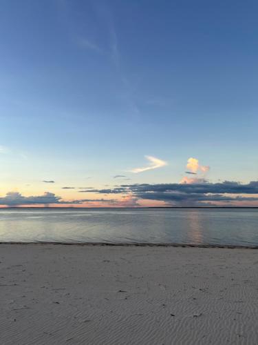 a view of a beach with the sun setting at Praia Grande Ecolodge in Manacapuru