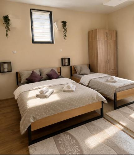 a bedroom with two beds with towels on them at Apartman Milica in Kremna
