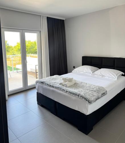 a bedroom with a large bed and a balcony at Villa Vuletic in Kula Atlagić