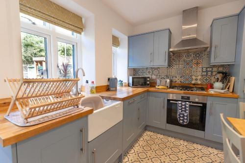 a kitchen with white cabinets and a sink at JACKS COTTAGE - Cosy Cottage in the Heart of Richmond in Richmond