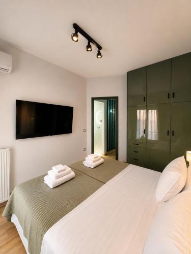 a bedroom with two beds and a flat screen tv at Zen Stay Maisonette in Igoumenitsa