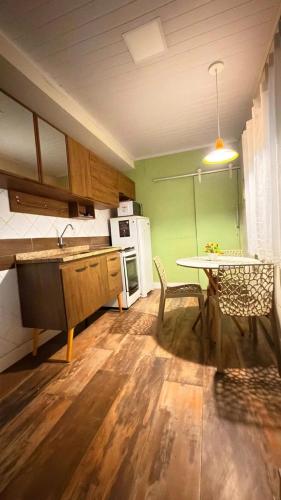 a kitchen with a table and a kitchen with green walls at Cantinho Aconchegante in Volta Redonda