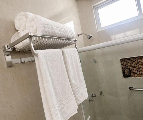 a bathroom with white towels on a towel rack at Hotel Summer Beach Paripueira Maceió in Paripueira