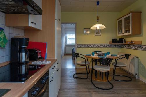 a kitchen with a small table and chairs in it at Ferienwohnung STEUERMANN in Werdum in Werdum