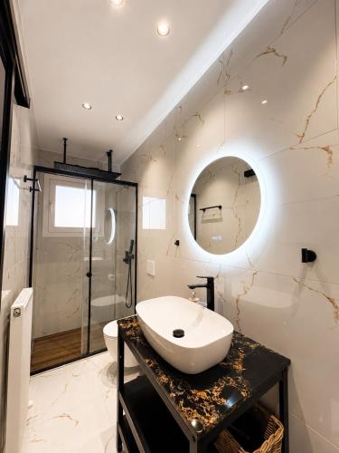 a white bathroom with a sink and a shower at Zen Stay Maisonette in Igoumenitsa