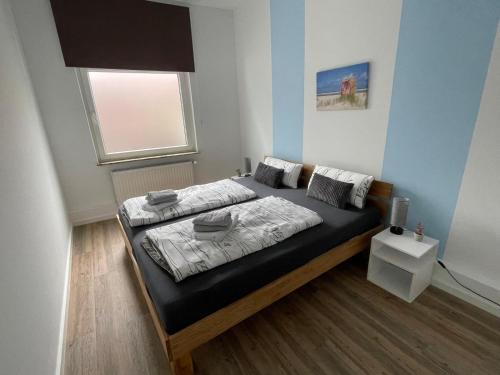 ein Schlafzimmer mit einem Bett in einem Zimmer mit Fenster in der Unterkunft Brigg in Emden