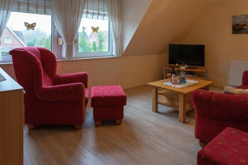 a living room with two chairs and a table at Ferienwohnung SCHIFFSJUNGE in Werdum in Werdum