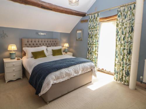 a bedroom with a bed and a large window at Green Farm Stables in Ashbourne