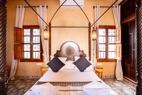 a bedroom with a large bed in a room with windows at Daba Village in Marrakesh
