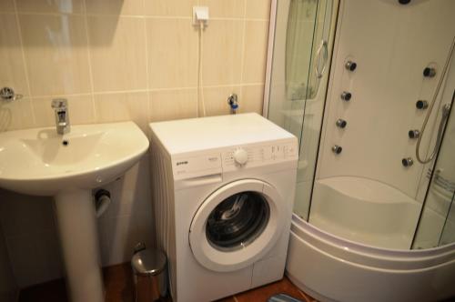 a bathroom with a washing machine and a sink at Guest House SAM-WATER in Đenovići