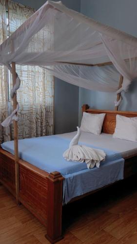a bedroom with a bed with a canopy at Paje Home away from home in Paje