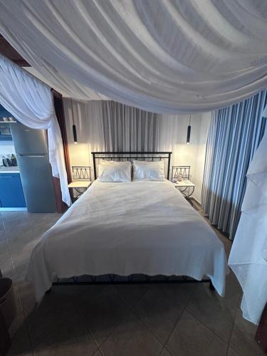 a bedroom with a large white bed with a canopy at Casa Gaia - Unit 1 in Glossa