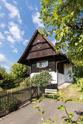 a wooden house with a bench and a fence at SCHILCHERLANDLEBEN - Bauernhaus in Sankt Stefan ob Stainz