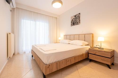 a bedroom with a large bed and a window at Theatre Home Aegean View in Nea Moudania