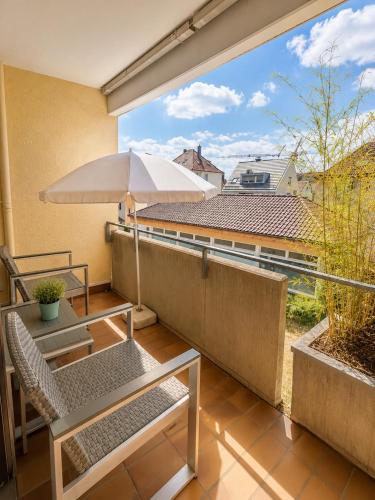 a balcony with a table and an umbrella at Apartment Balkon Parkplatz Arbeitsplatz in Reutlingen