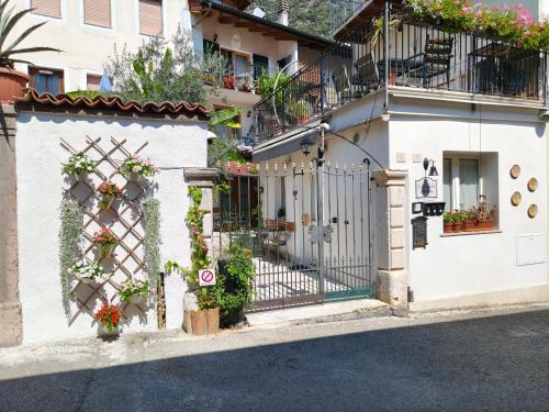 a white building with a gate and flowers on it at La Bouganville in Arco