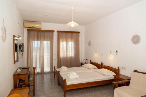 a bedroom with two beds and a couch at Jimmy Anna Apartments in Votsalákia