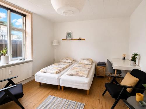 a living room with two beds and a table at Lejlighed midt i Thisted in Thisted