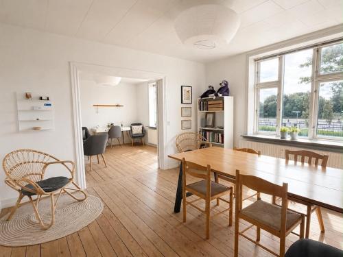 a living room with a wooden table and chairs at Lejlighed midt i Thisted in Thisted