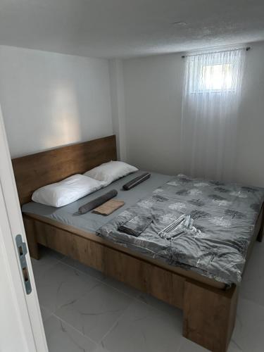 a bedroom with a bed with a wooden frame at Sarajevo Days in Binježevo