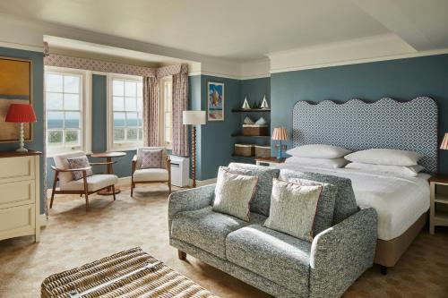 a bedroom with a bed and a couch and a chair at Bournemouth Highcliff Marriott Hotel in Bournemouth