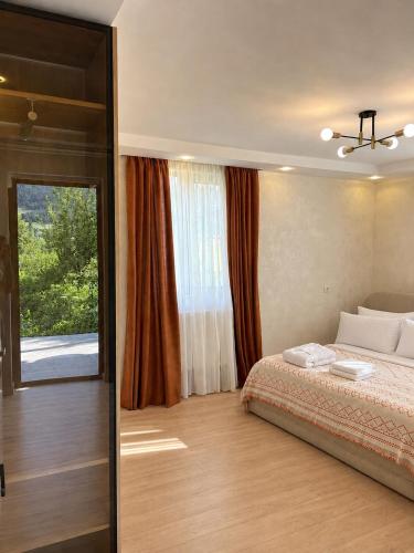 a bedroom with a bed and a large window at Cherry Guesthouse in Tsalka