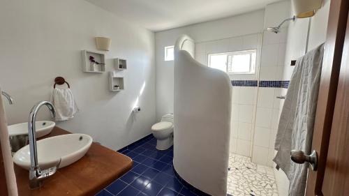 a white bathroom with a sink and a toilet at Casa Bella Mya in Taganga