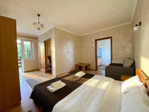 a bedroom with a large bed and a living room at Котедж в горах у Антоніни in Solochyn