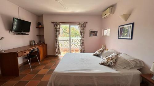 a bedroom with a bed and a desk and a television at Casa Bella Mya in Taganga