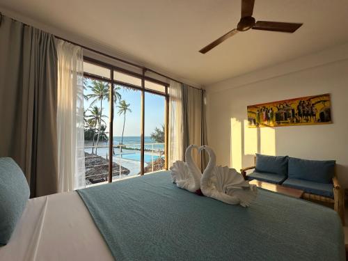a bedroom with a bed with a view of the ocean at Belvedere Resort in Jambiani