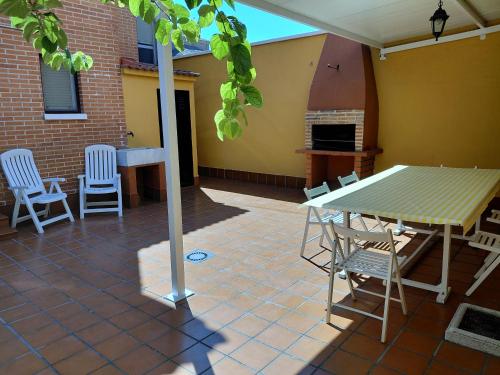 a patio with a table and chairs and a fireplace at CHALET Cubo de las Monjas in Nava del Rey