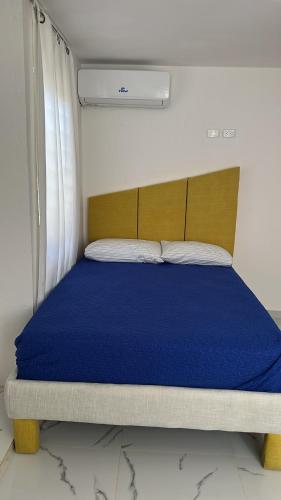 a bedroom with a bed with a blue bedspread at Carrasco D in Nagua