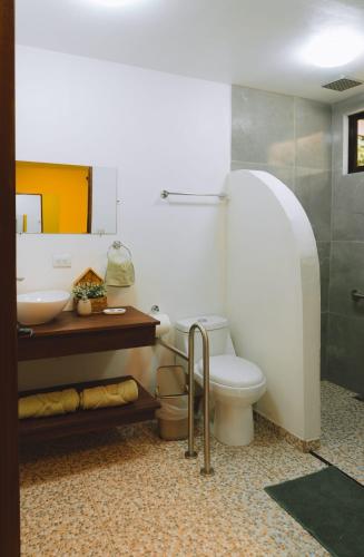 a bathroom with a toilet and a sink at Hospedaje Río Palomo in Orosí