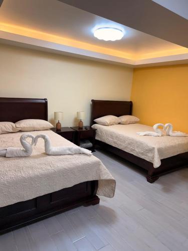 a room with two beds with white towels on them at Hospedaje Río Palomo in Orosí