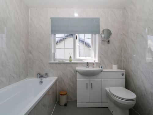 a bathroom with a toilet and a sink and a tub at Fountain Cottage in Keswick