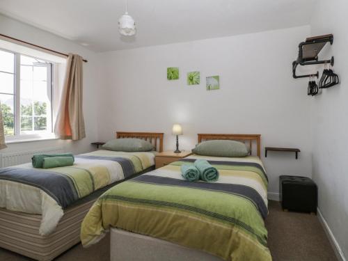 two beds sitting in a room with a window at Fountain Cottage in Keswick