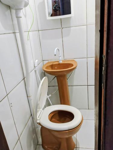 a bathroom with a toilet and a sink at suíte feliz in Belém